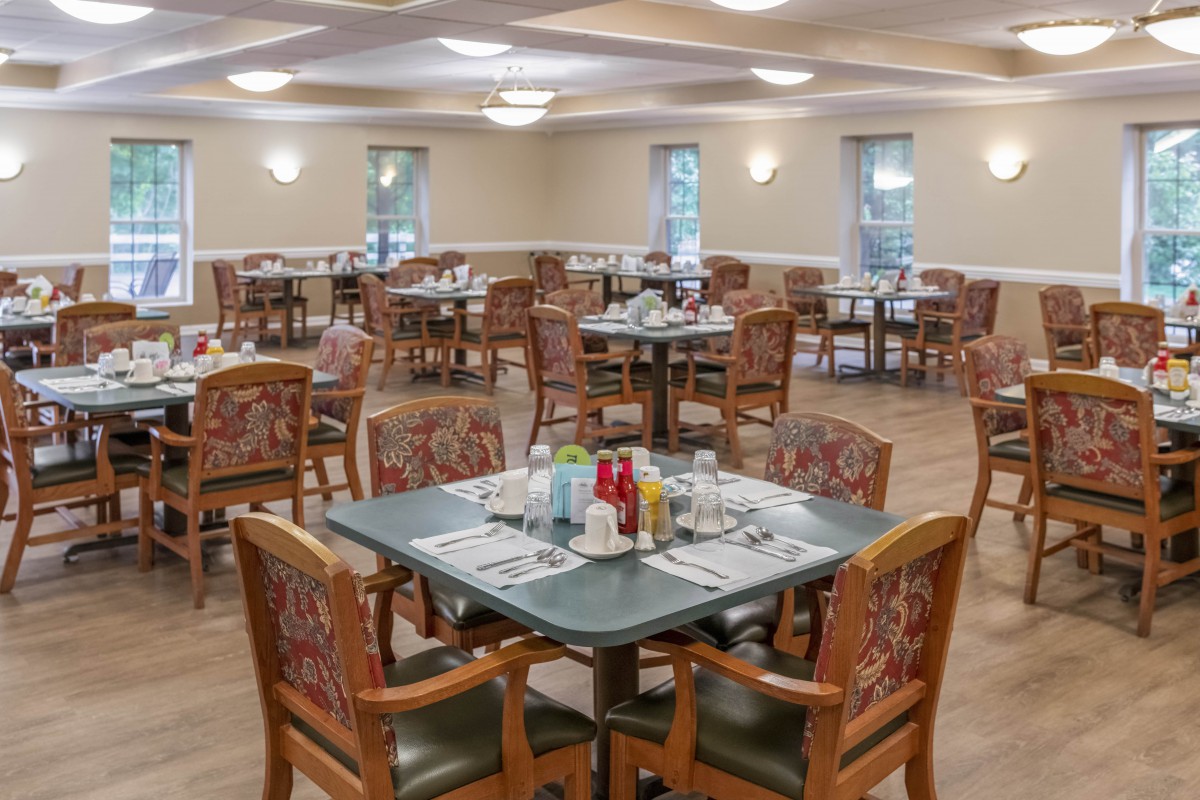 An empty dining room with neatly arranged tables and chairs.