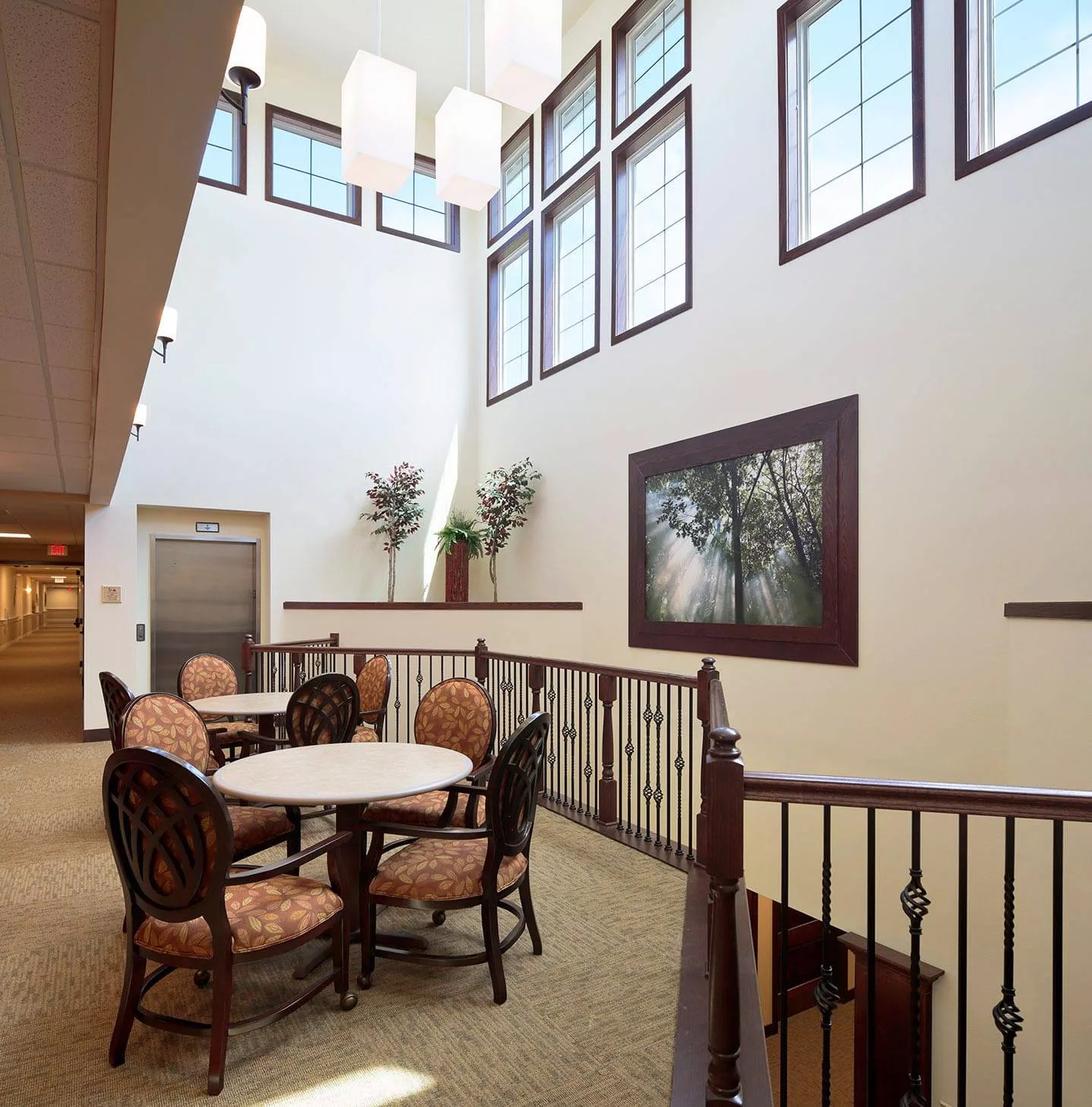 A modern interior space with a round table and chairs, large windows, and elegant decor.