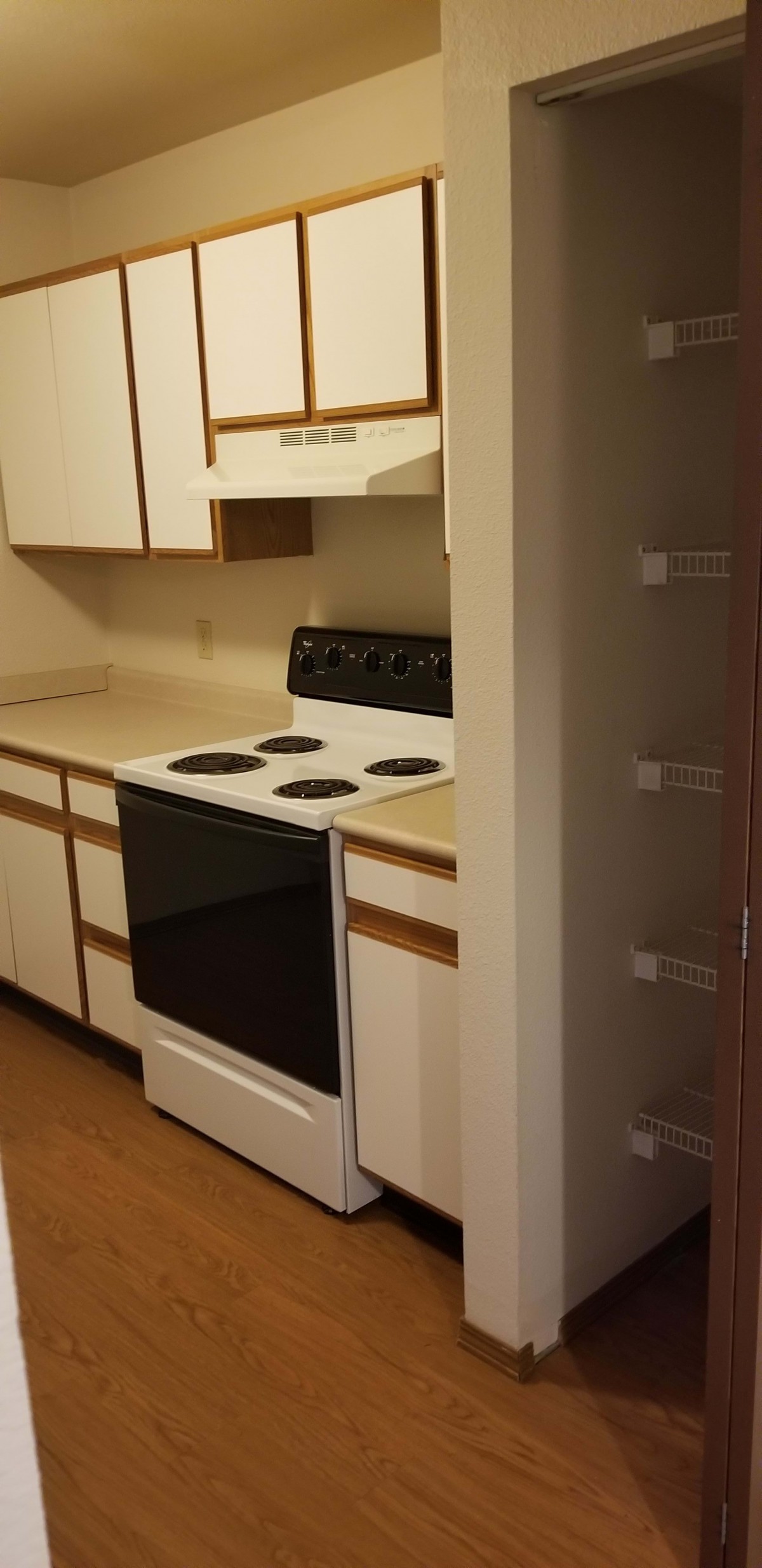 A compact kitchen with a stove and white cabinets.