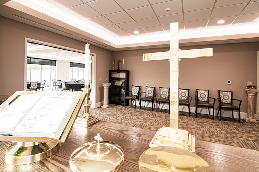A serene chapel setting featuring a prominent cross and seating for reflection or ceremony.
