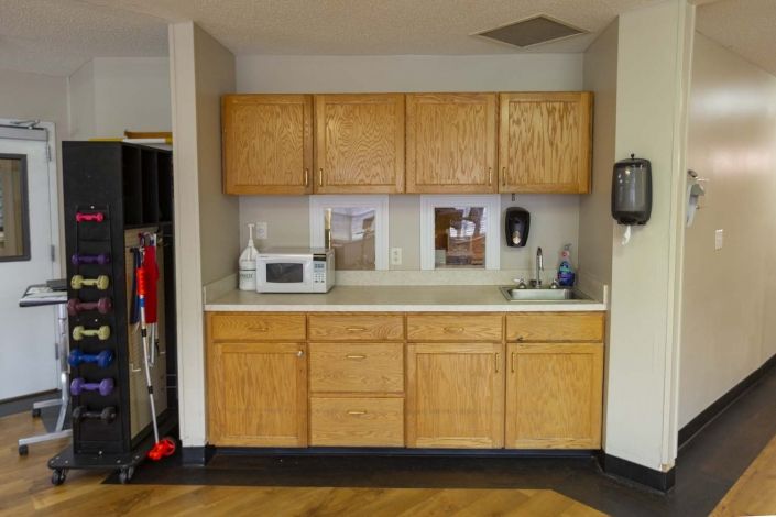 A simple kitchen setup with wooden cabinets and a microwave on the countertop.