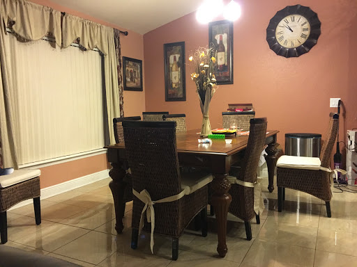 A cozy dining room featuring a wooden table surrounded by chairs, adorned with elegant wall decor and a warm color palette.