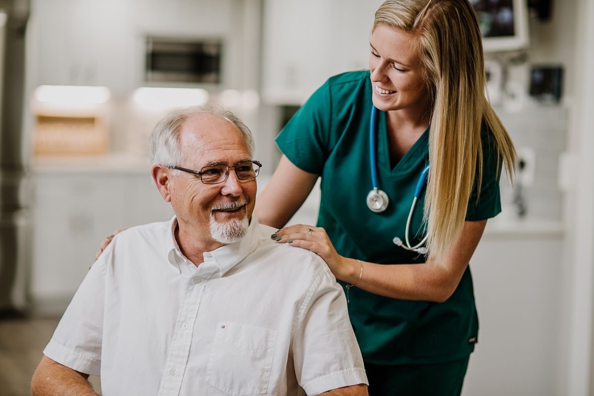 A nurse providing care and support to an elderly patient.