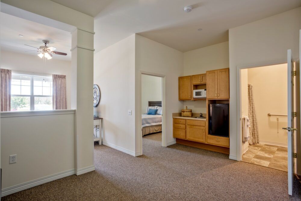 A modern apartment with an open layout featuring a compact kitchen and adjacent bedrooms.
