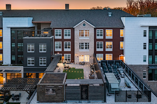 A beautifully designed courtyard surrounded by contemporary buildings at sunset.