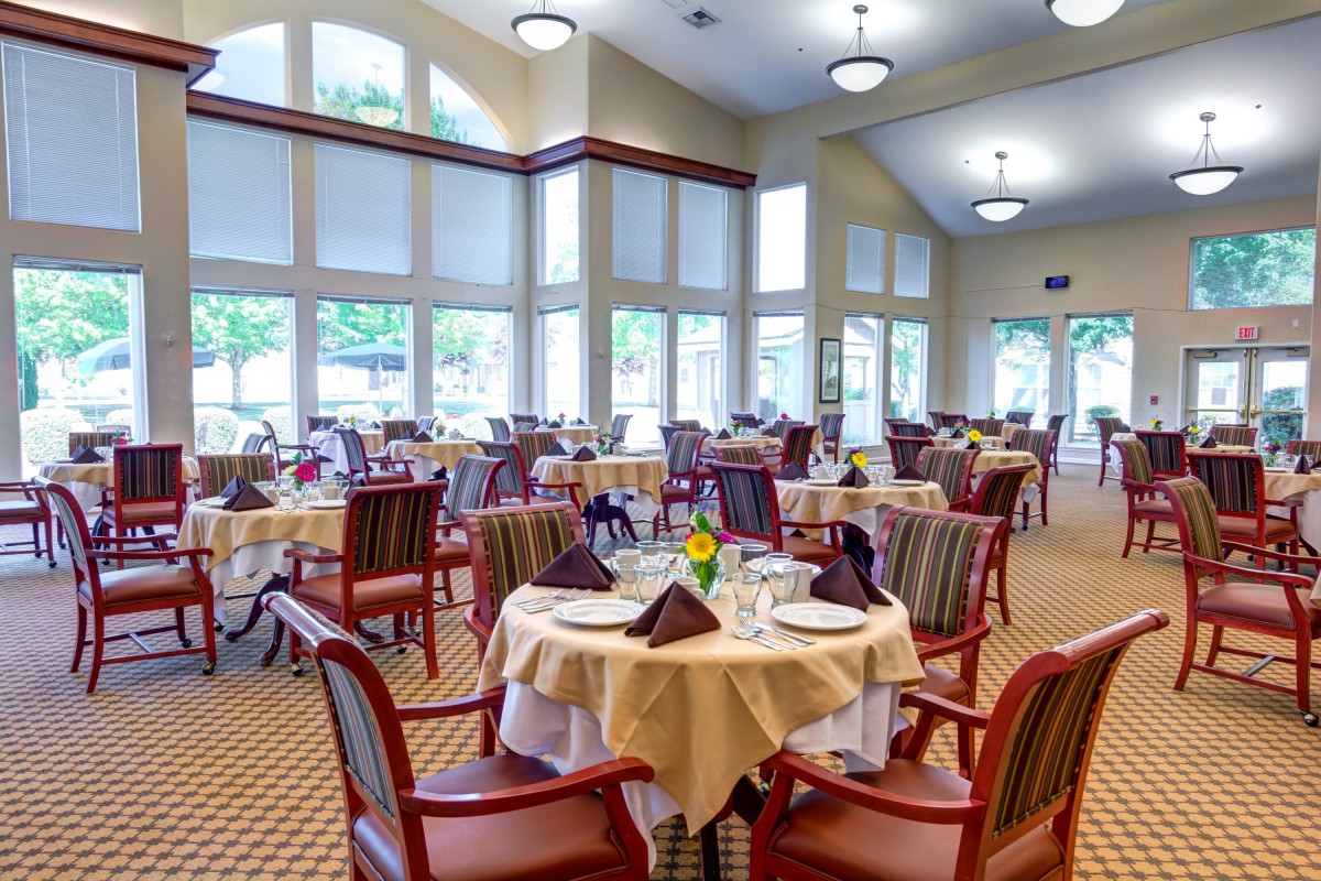A well-lit dining area with neatly arranged tables and chairs.