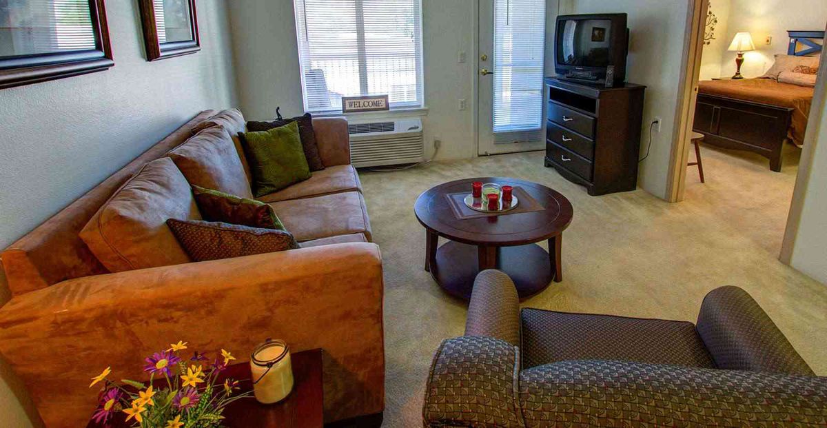 A cozy living room featuring a sofa, coffee table, and television.