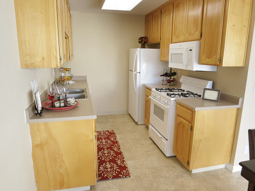 A cozy kitchen featuring light wooden cabinets and essential appliances, perfect for cooking and dining.