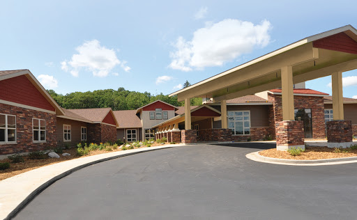A welcoming residential building set against a lush, green backdrop.