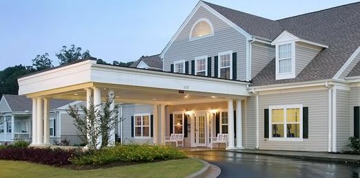A colonial-style house with a covered entrance and white exterior.