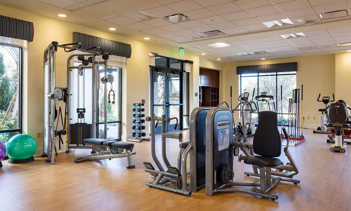 A modern gym with various exercise equipment and a spacious workout area.