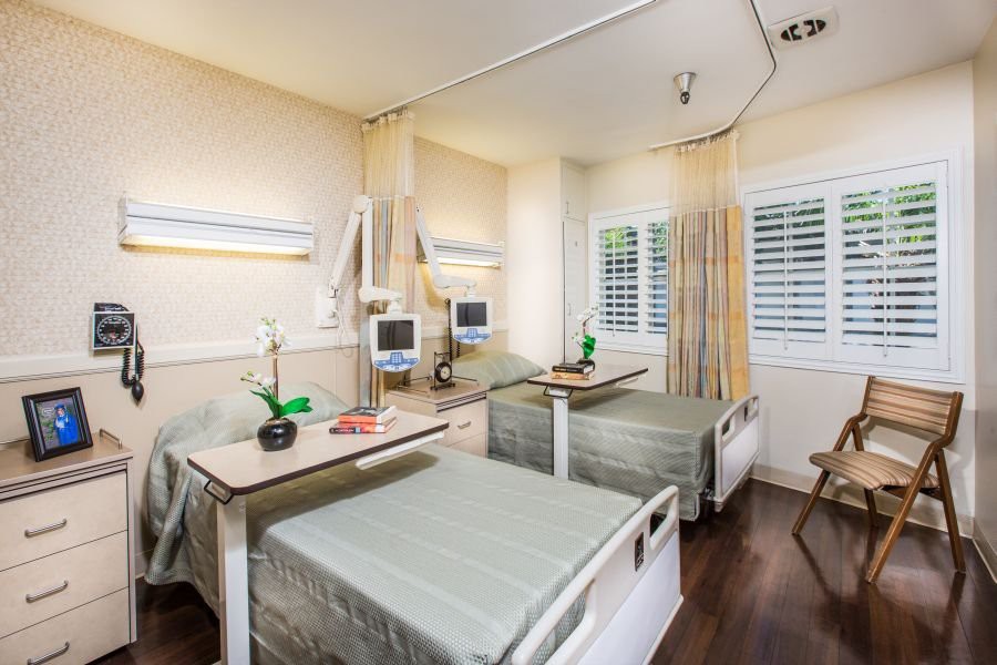 A clean and organized hospital room with two patient beds, medical equipment, and a serene atmosphere.