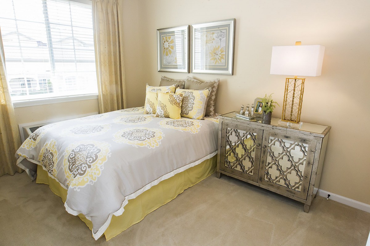 A cozy bedroom with elegant decor, featuring a neatly made bed, stylish nightstand, and warm lighting.