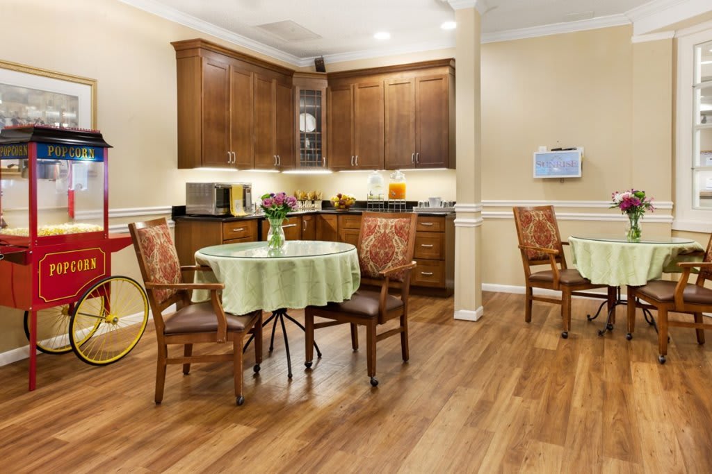 A cozy kitchen and dining area with wooden cabinetry and a table set for two.