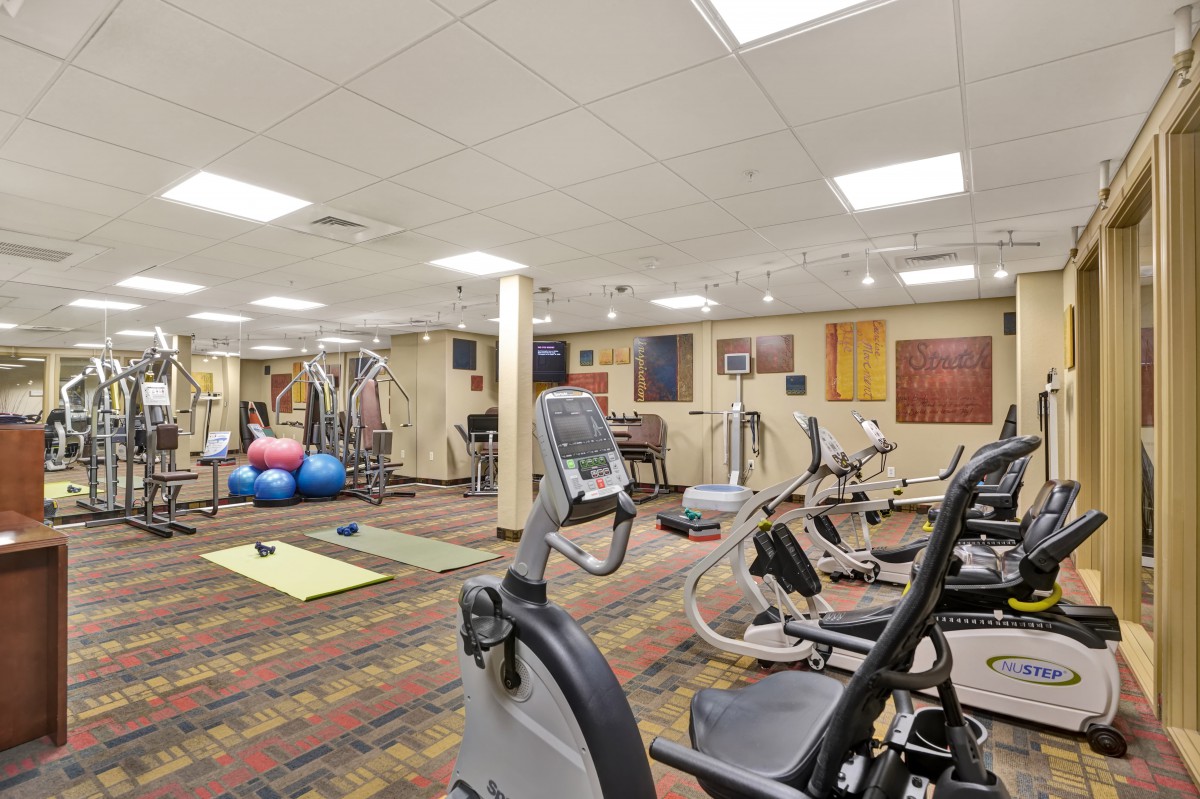 A well-equipped fitness center with various exercise machines and free weights.