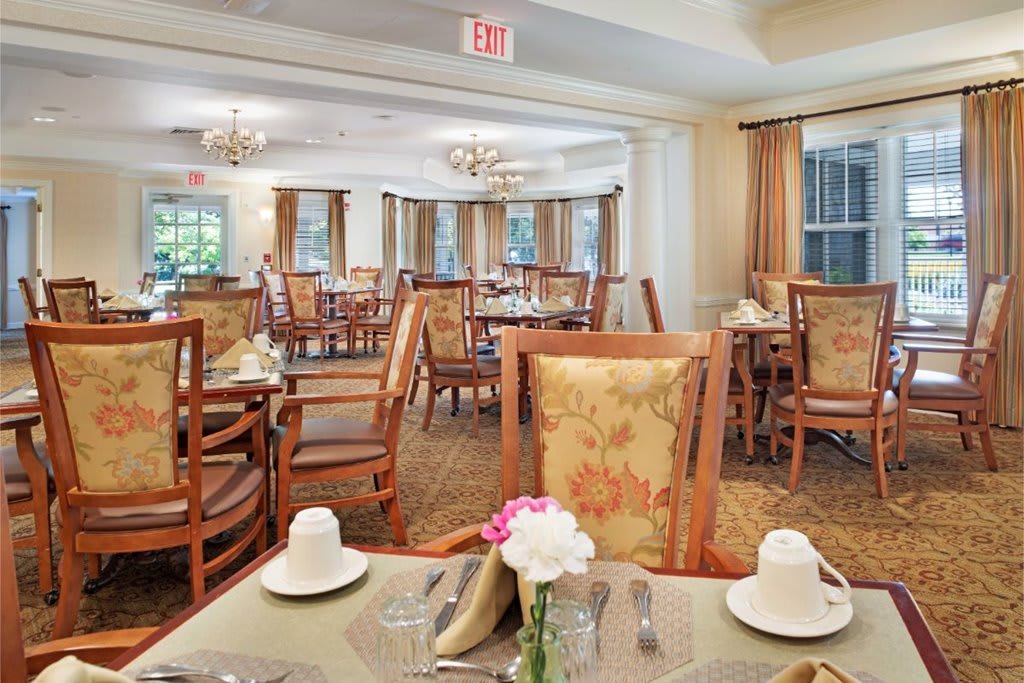 An elegant dining room interior with neatly arranged tables and chairs, adorned with decorative elements.