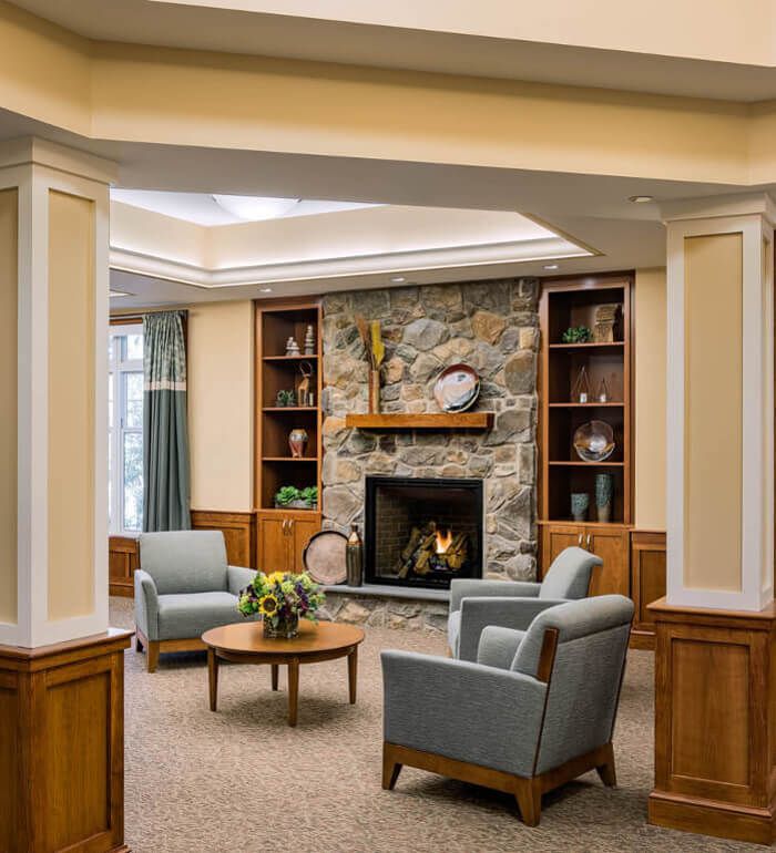 A cozy living room with a stone fireplace and comfortable seating arrangement.
