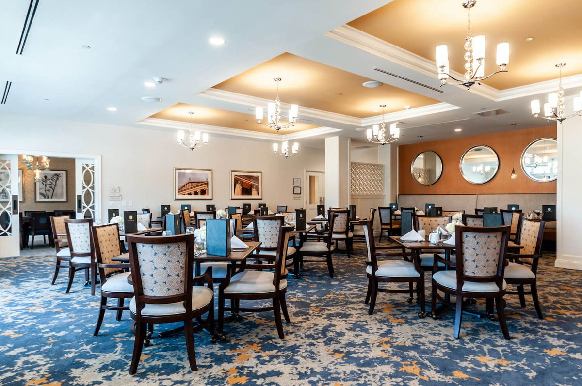 A beautifully decorated dining room with elegant chandeliers and well-arranged tables and chairs.