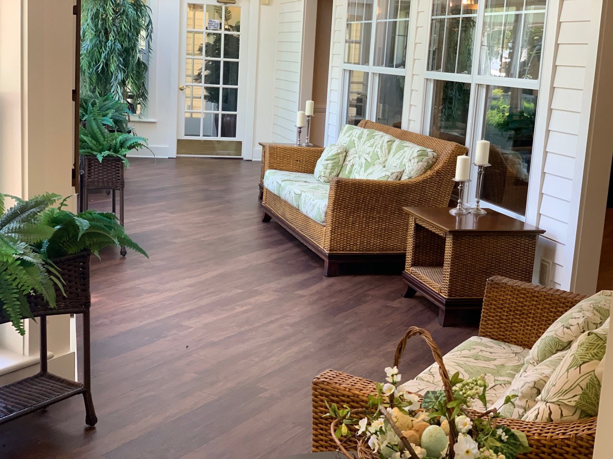 A cozy sunroom with wicker furniture and lush indoor plants.
