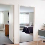A well-lit apartment interior with two adjoining rooms visible through open doorways.