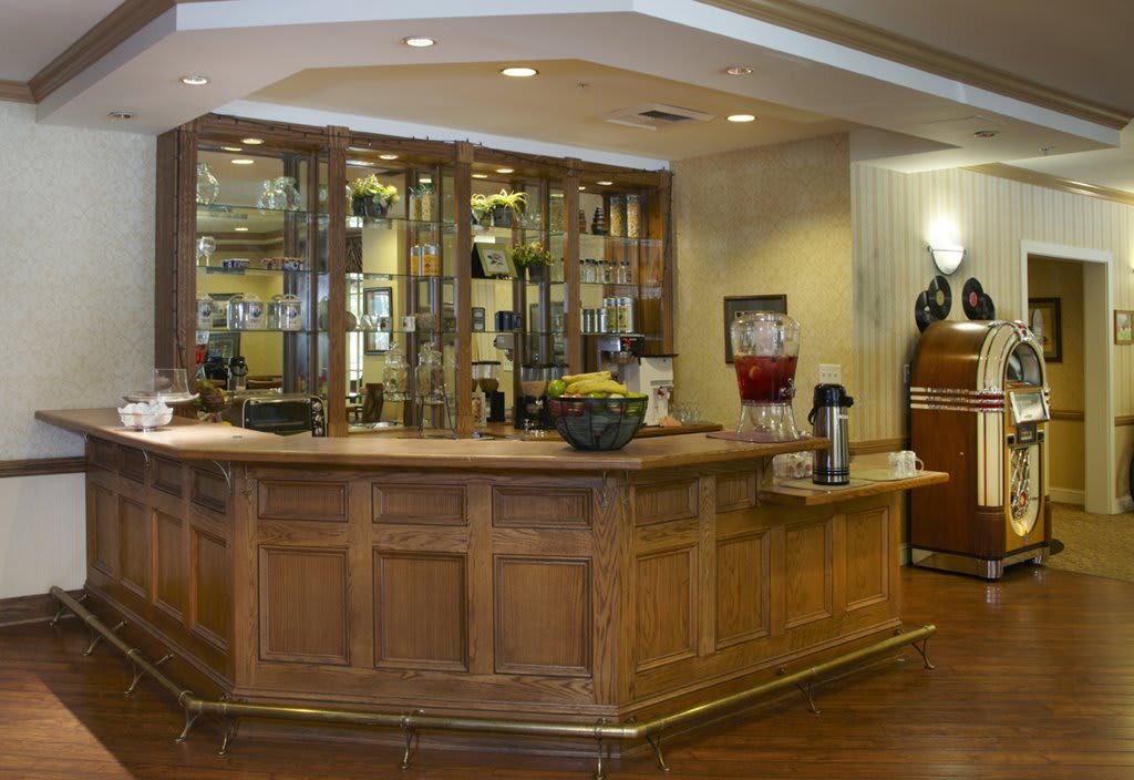 A hotel reception area with a wooden counter and refreshments.