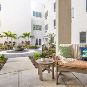 A modern courtyard with comfortable seating and lush plants.