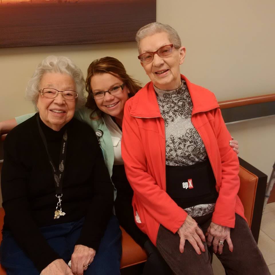 Three women sitting together indoors, smiling for a photo.