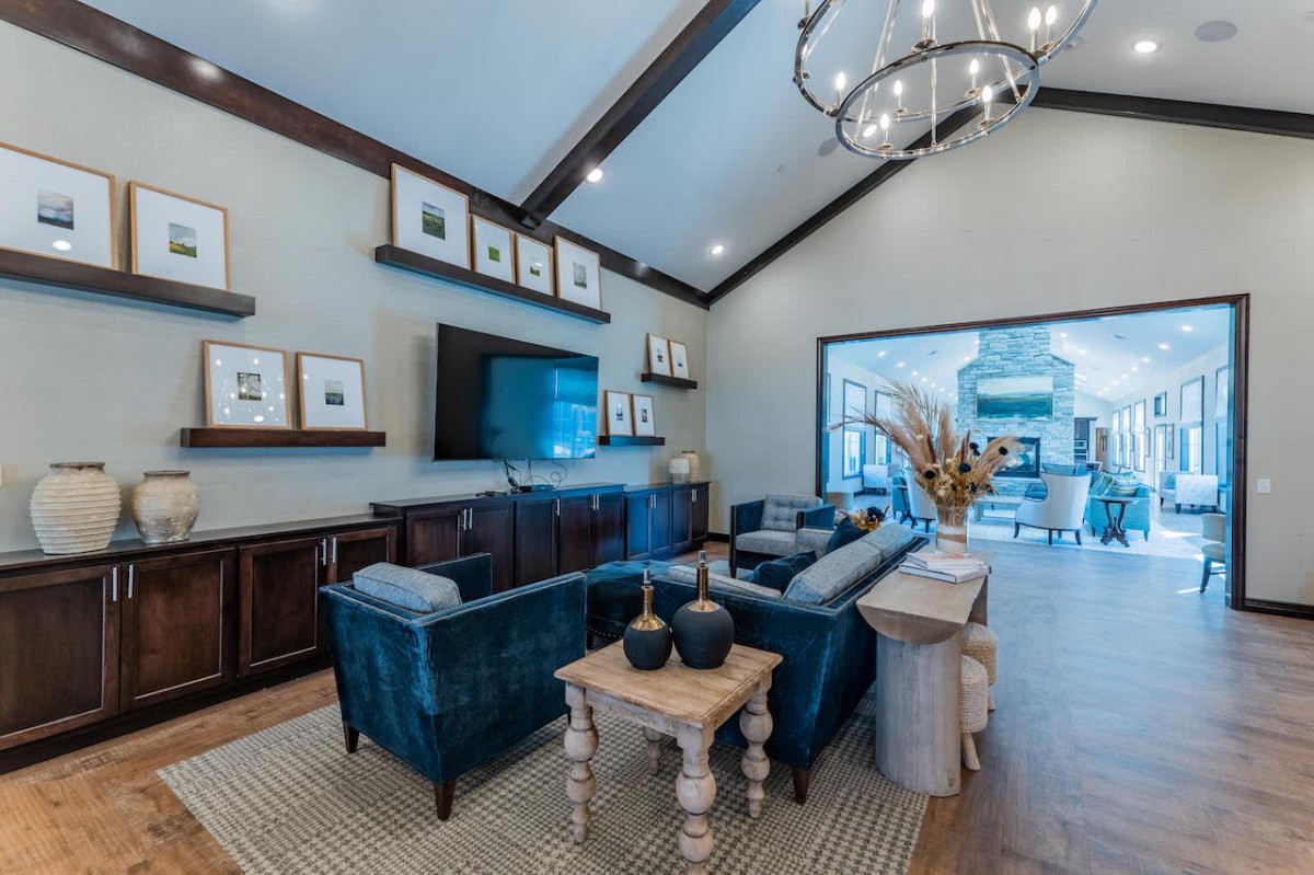 Modern living room with a cozy seating area and elegant chandelier.