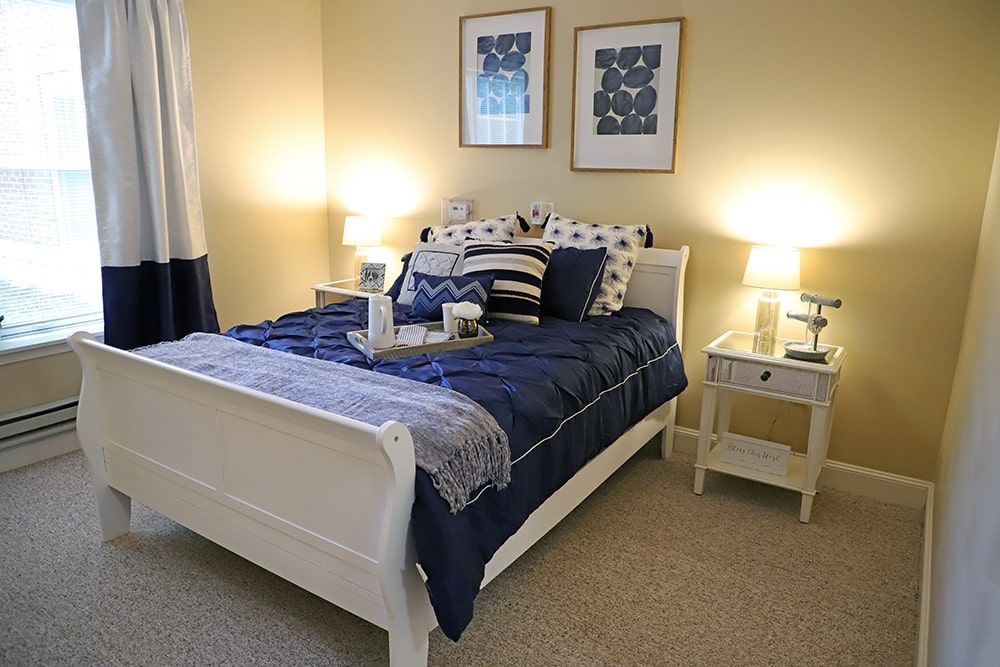 A cozy bedroom with a neatly made bed, nightstands, and decorative lamps.