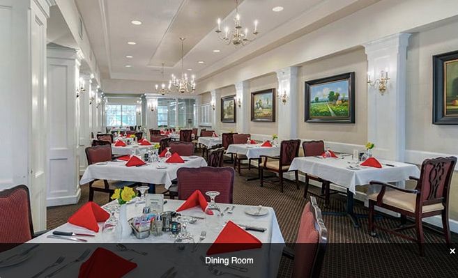 A well-decorated dining area with elegantly set tables and artwork on the walls.