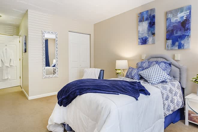 A cozy bedroom with blue accents and modern decor.