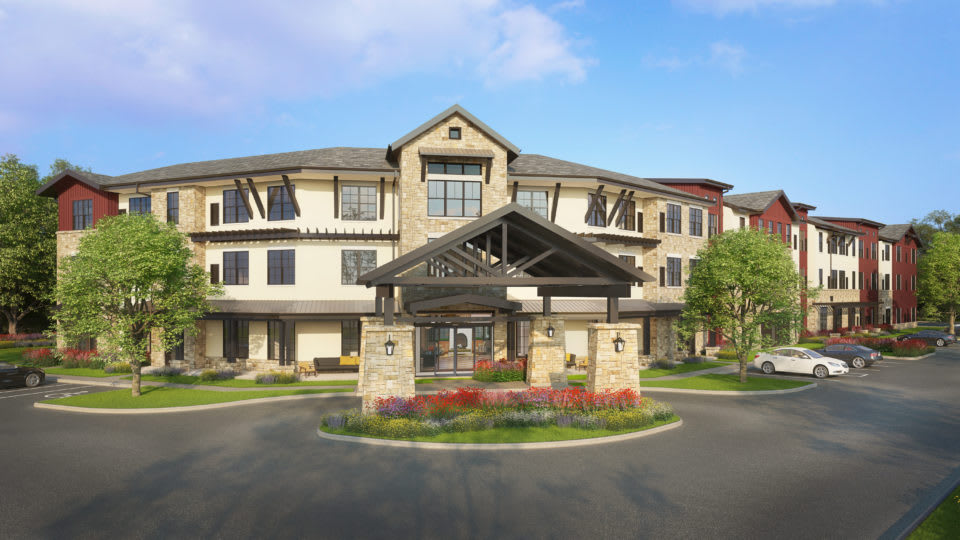 A modern residential building with a landscaped entrance and stone accents.