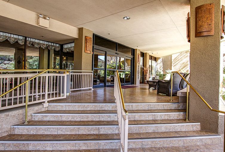 Entrance with stairs and outdoor seating at a building.