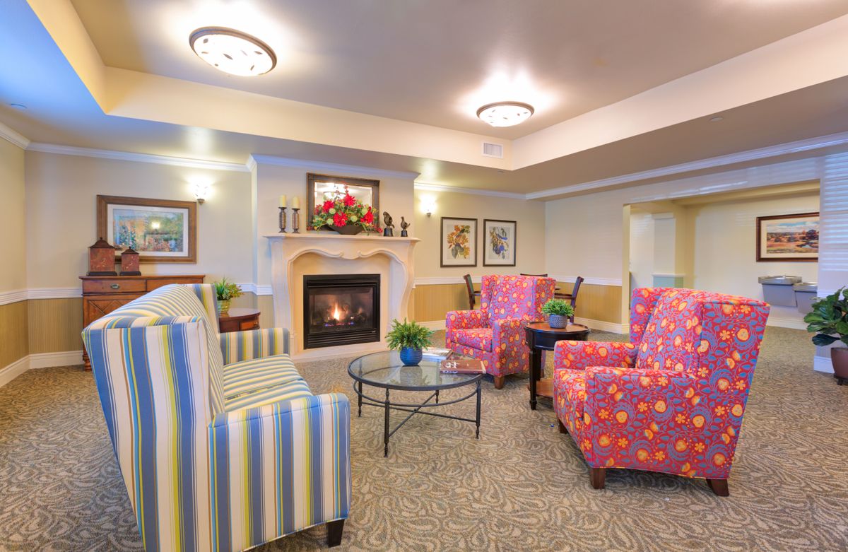 A cozy living room with a fireplace and colorful seating area.