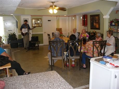 A group of people enjoying a social gathering with live music in an indoor setting.