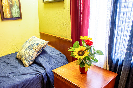 A cozy bedroom corner featuring a comfortable bed and a vibrant floral arrangement.