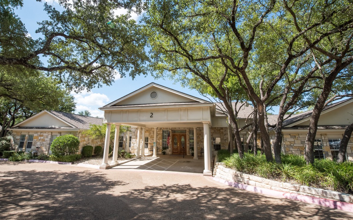 A classic building entrance surrounded by trees.