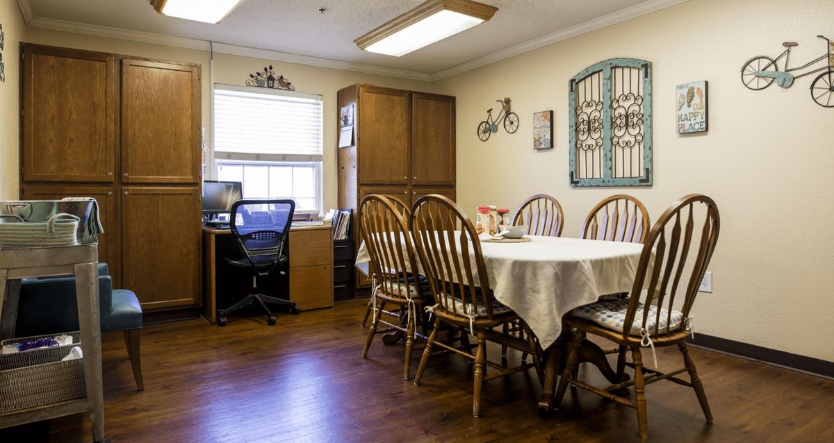 A cozy dining area featuring a table with chairs and a small office corner.