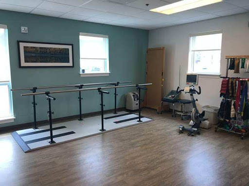 A spacious rehabilitation room equipped with ballet bars and exercise equipment, designed for physical therapy sessions.