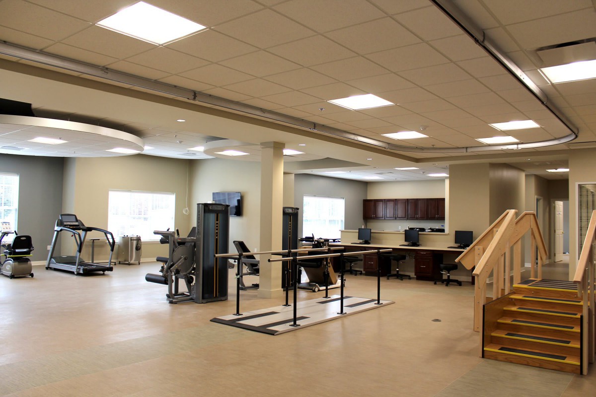 A modern gym interior with various exercise equipment and workout spaces.