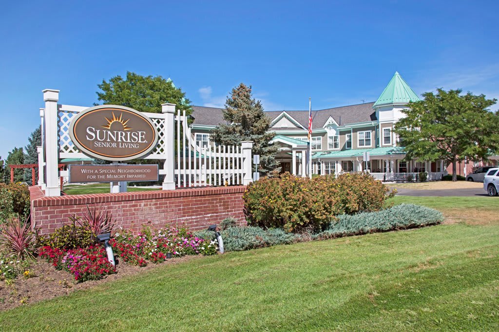 A nursing home with well-maintained landscaping and clear signage on a sunny day.