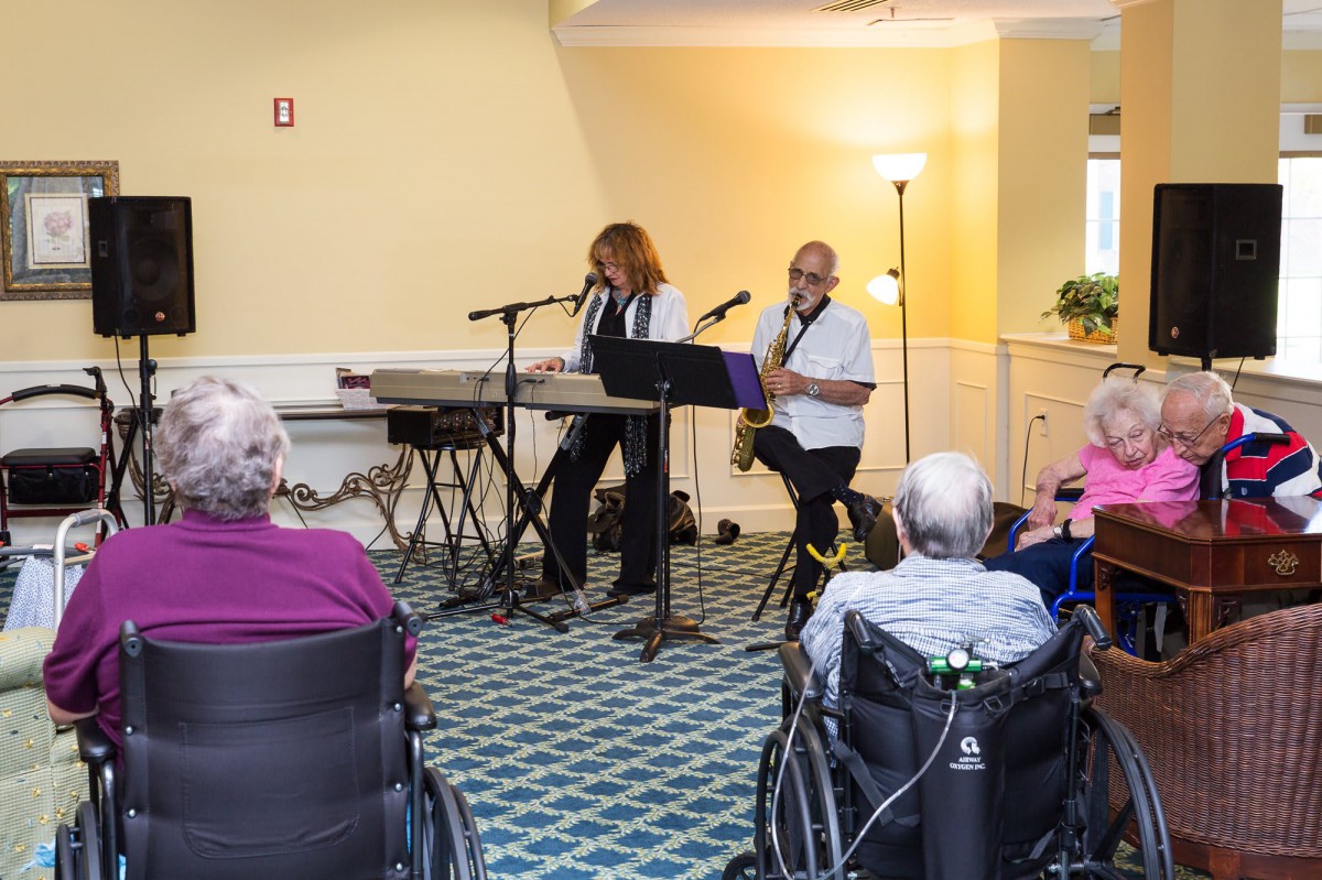 Musicians perform for an audience in an indoor setting.