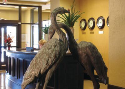 A decorative sculpture of two cranes displayed indoors.
