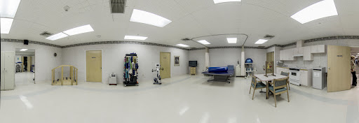 A modern medical room featuring a robot and advanced medical equipment.