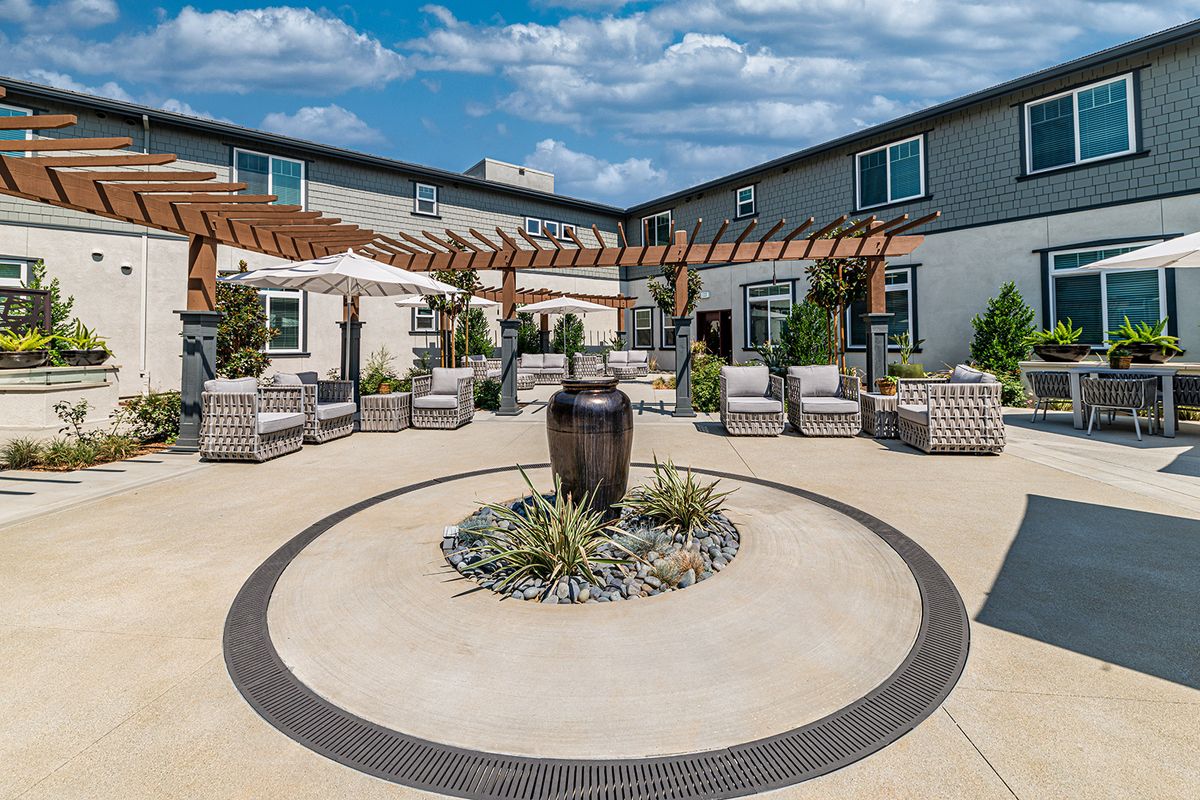A beautifully designed courtyard with a central fountain, surrounded by seating and landscaping.