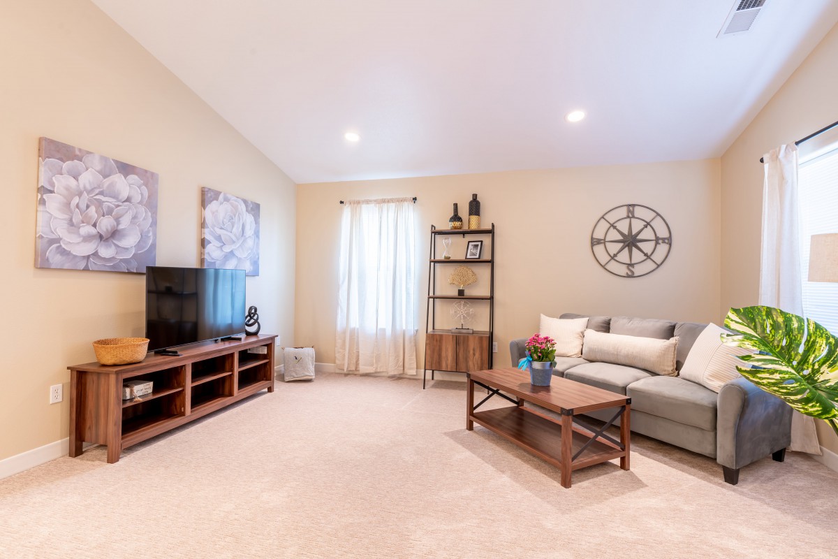 A cozy living room with a sofa, coffee table, television, and decorative elements.