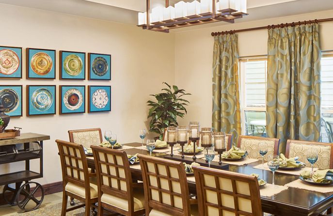 A well-decorated dining room with a large table, elegant chairs, and contemporary artwork on the walls.