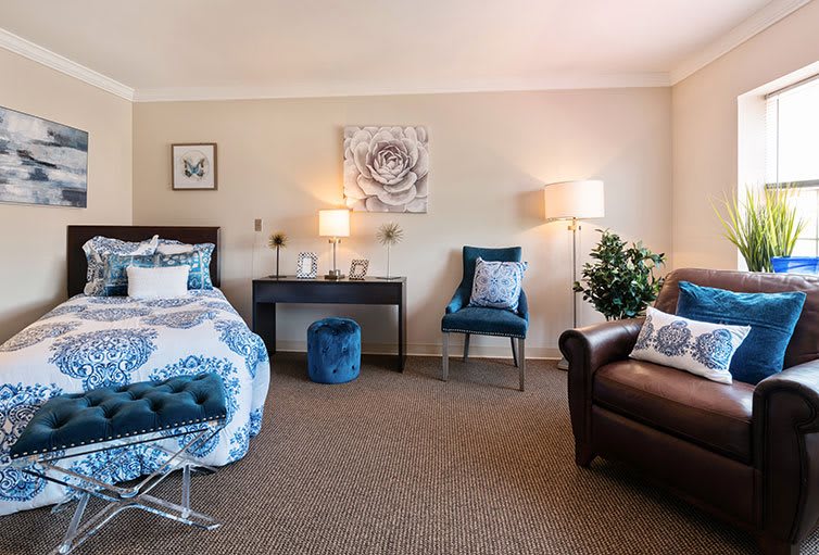 A cozy bedroom featuring a bed, comfortable chairs, and tasteful decor.
