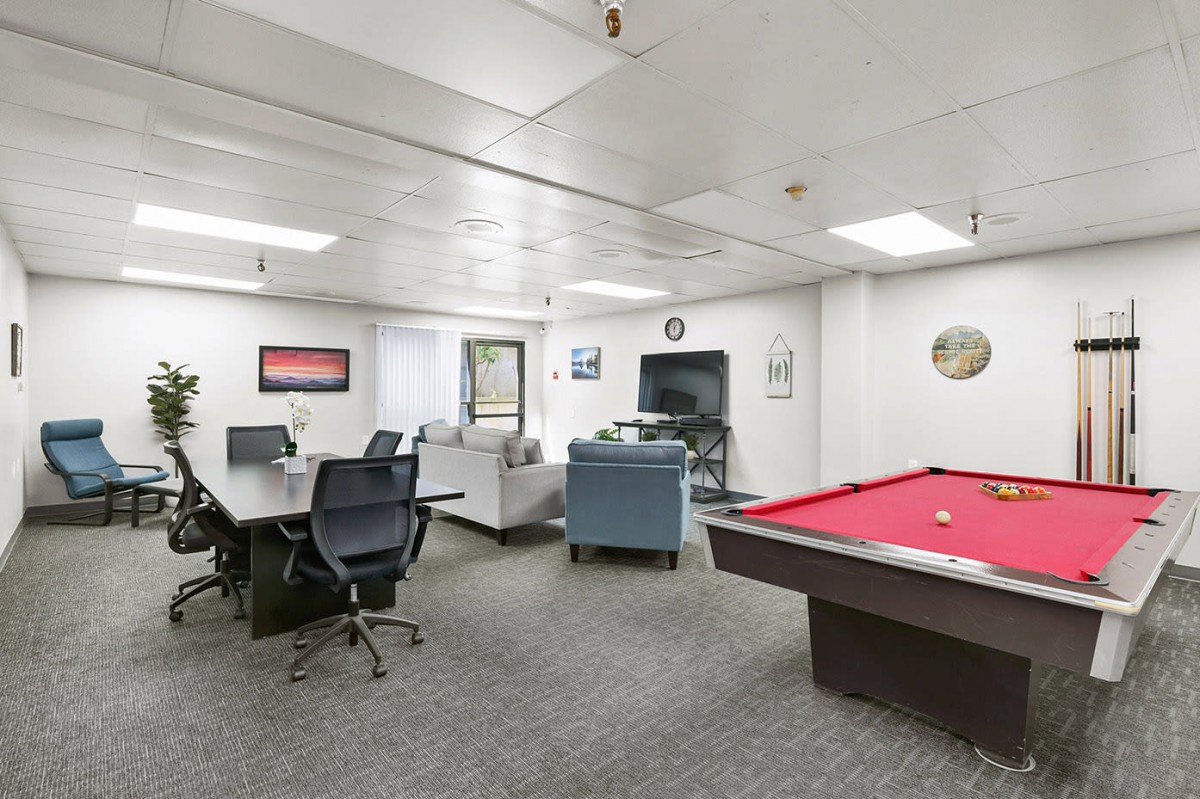 A modern office space featuring a conference area and a pool table.