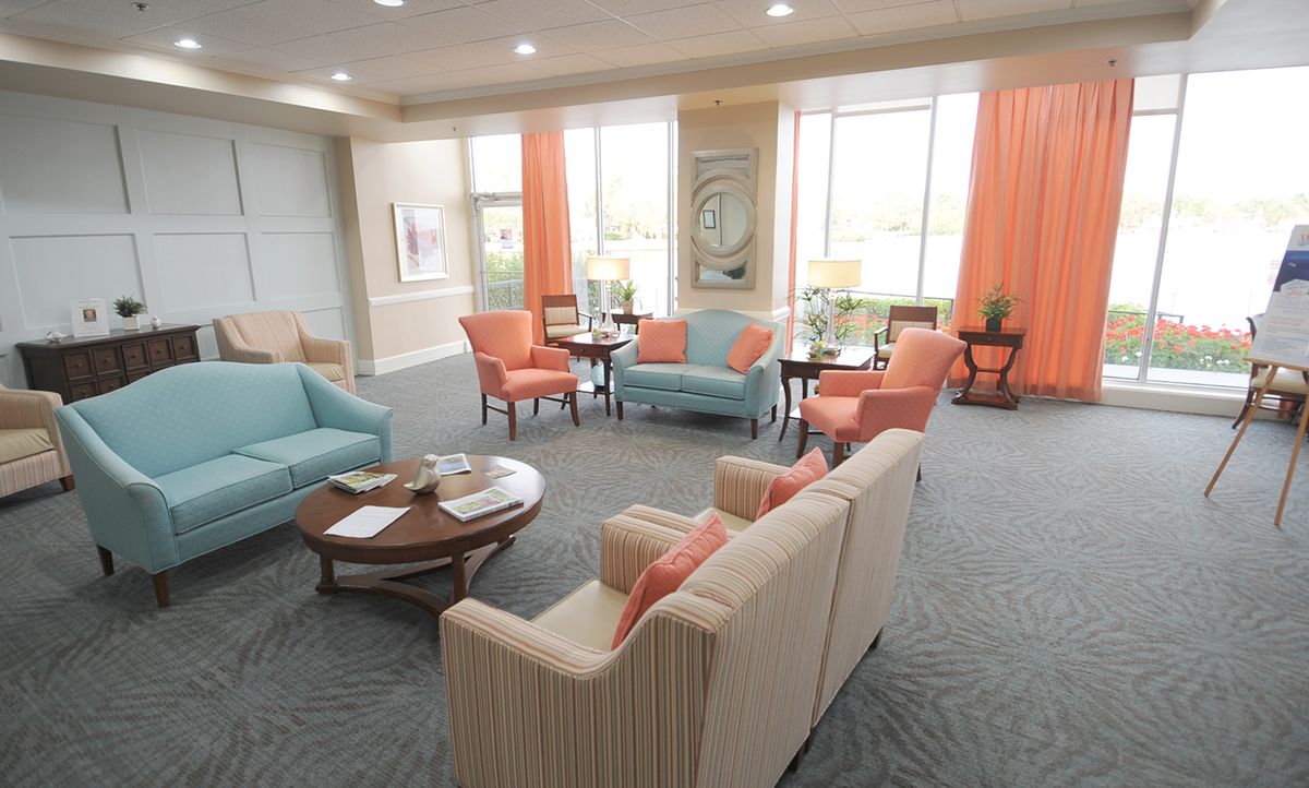 A cozy and elegantly styled living room with pastel-colored sofas, armchairs, and a coffee table.